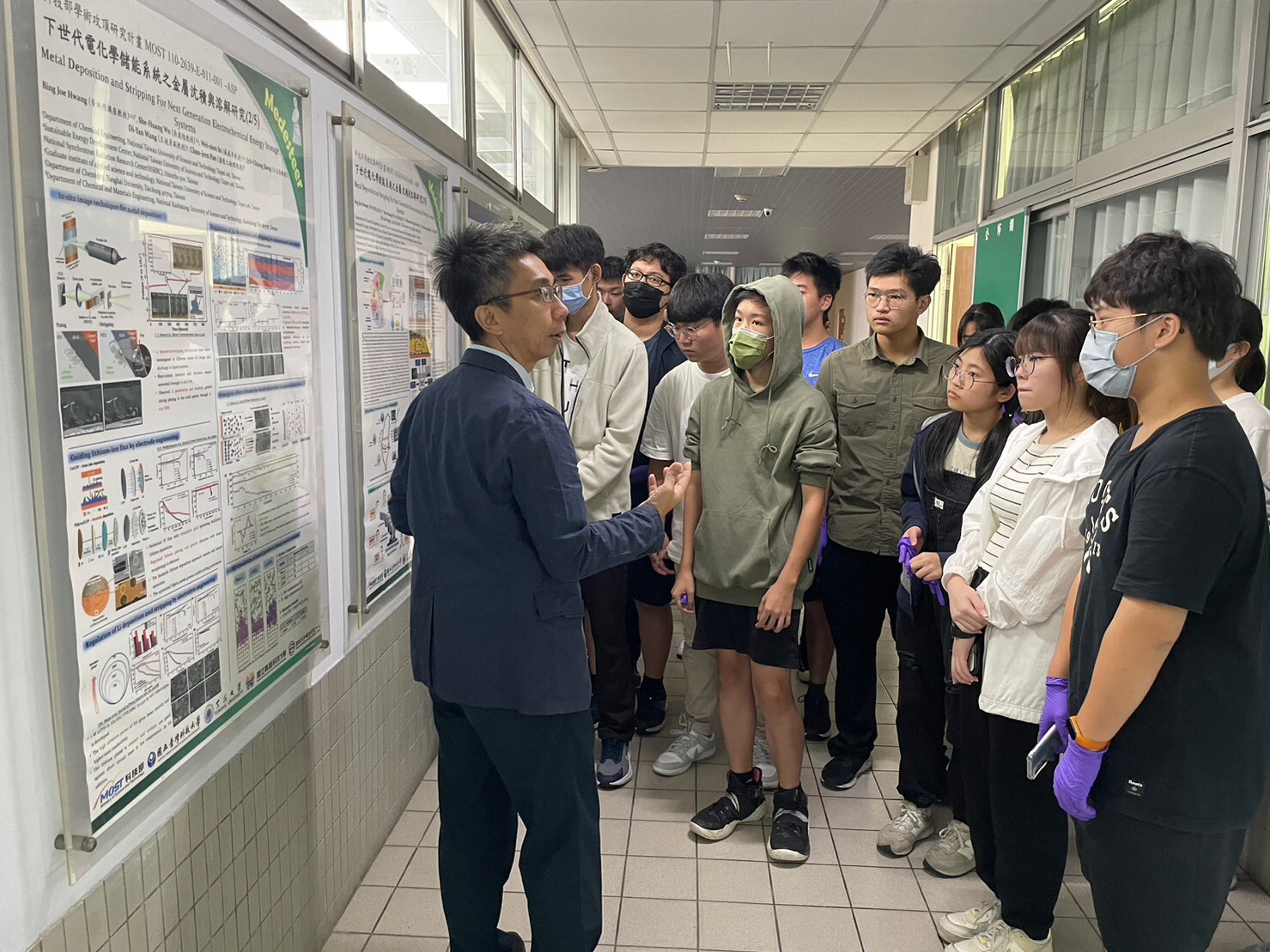 蘇威年教授(左一)向學生詳細介紹電化學儲能系統的研究成果。