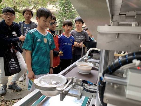 供臺科大研發團隊邀請公館國小學童一起體驗機器人煮麵,近距離觀摩先進的自動化烹飪技術。(臺科大提供