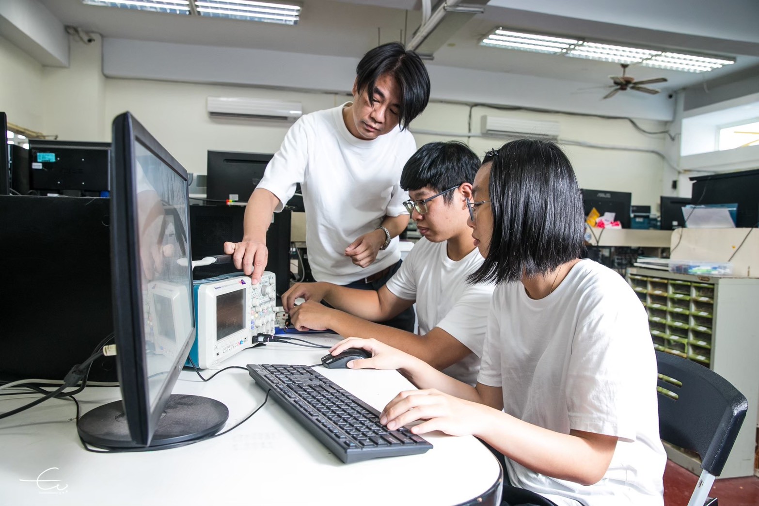 臺科大學電機工程系謝易錚教授(左一)帶領學生利用示波器開發電機相關技術。