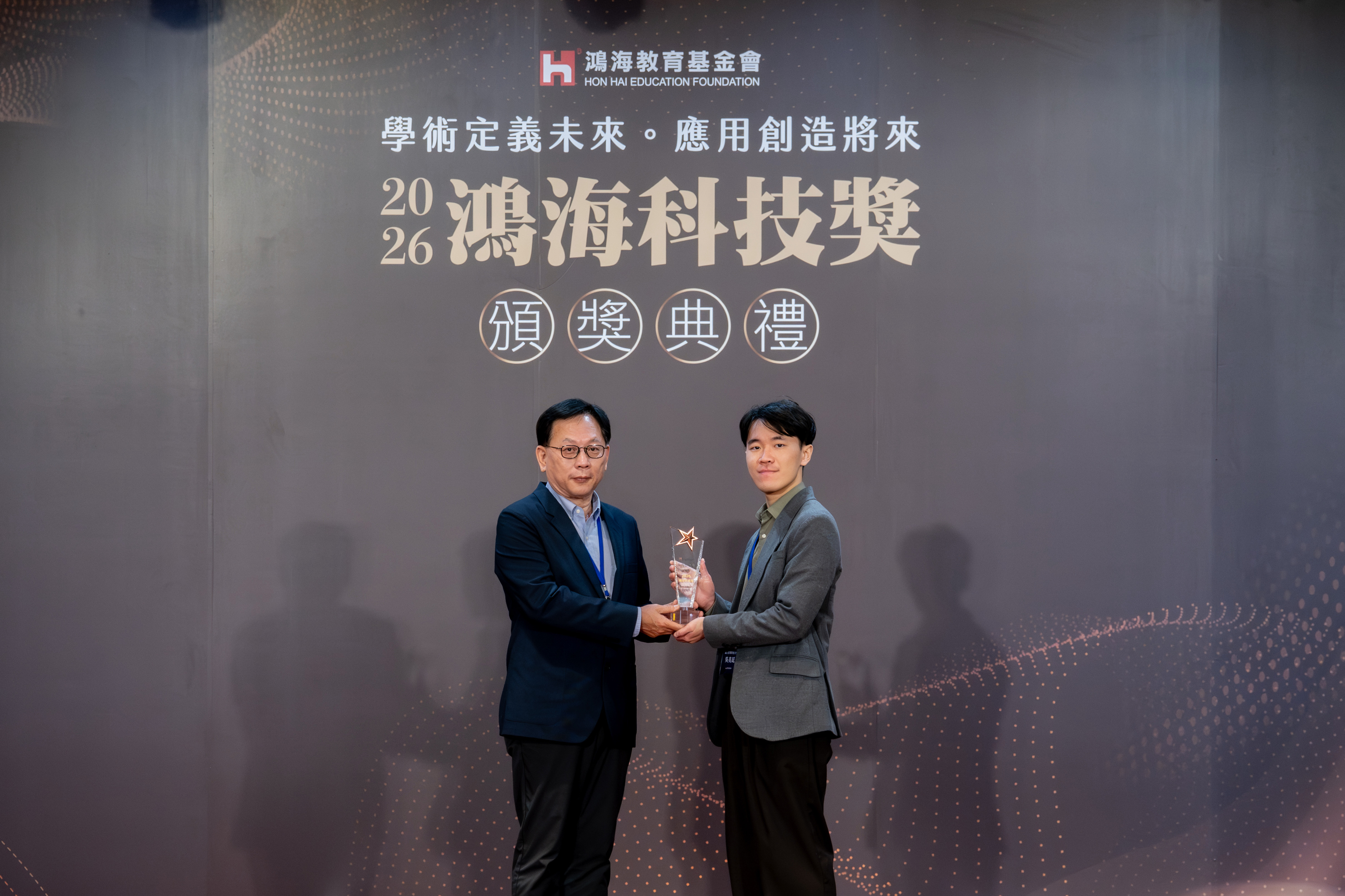 國立臺灣科技大學化工系博士生吳亮廷(右)榮獲2026鴻海科技獎應用組肯定,於頒獎典禮接受頒獎,研究成果展現臺科大在人工智慧與能源材料跨域研究的實力。