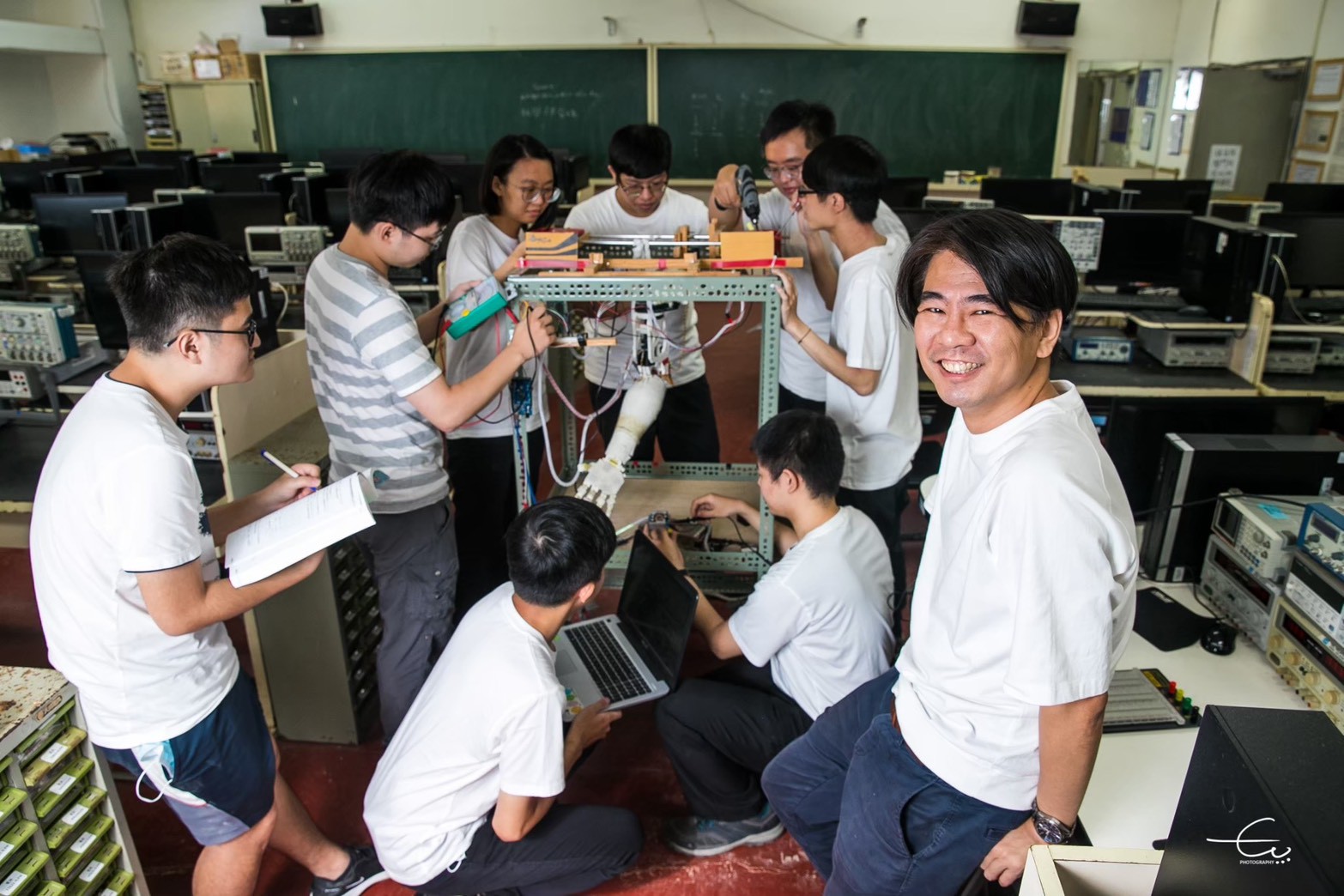 謝易錚教授(右一)帶領臺科大電機系學生進行系統研發與實驗,他長期指導學生參與研究與競賽,培育許多具備跨域研發能力的工程人才。