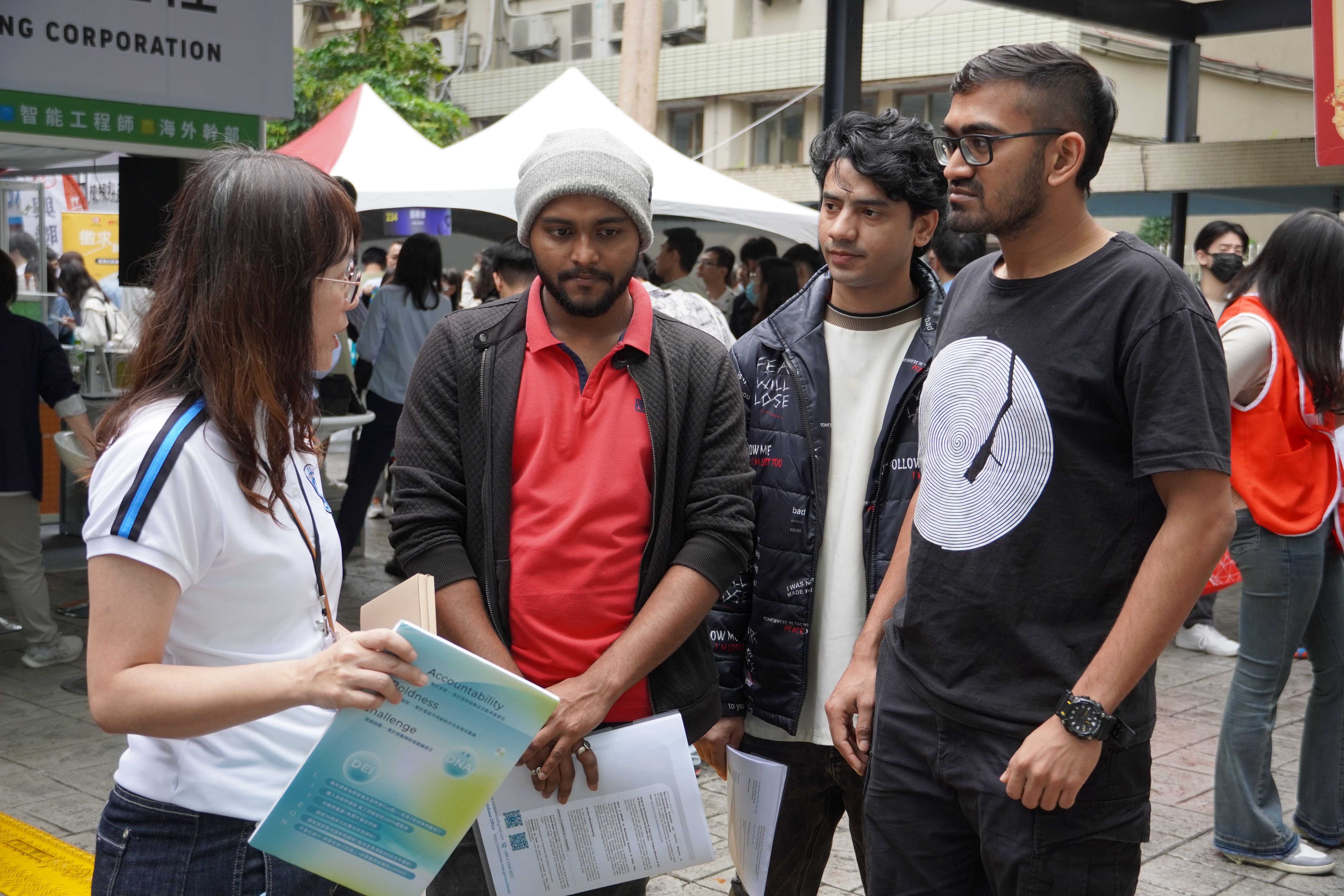 Approximately 12% of Taiwan Tech's students are international students. The image shows foreign students inquiring at the booths.